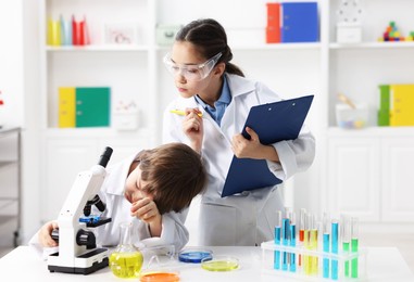 Photo of Children doing chemical experiment at desk indoors