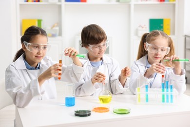 Photo of Children doing chemical experiment at desk indoors