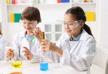 Photo of Children doing chemical experiment at desk indoors