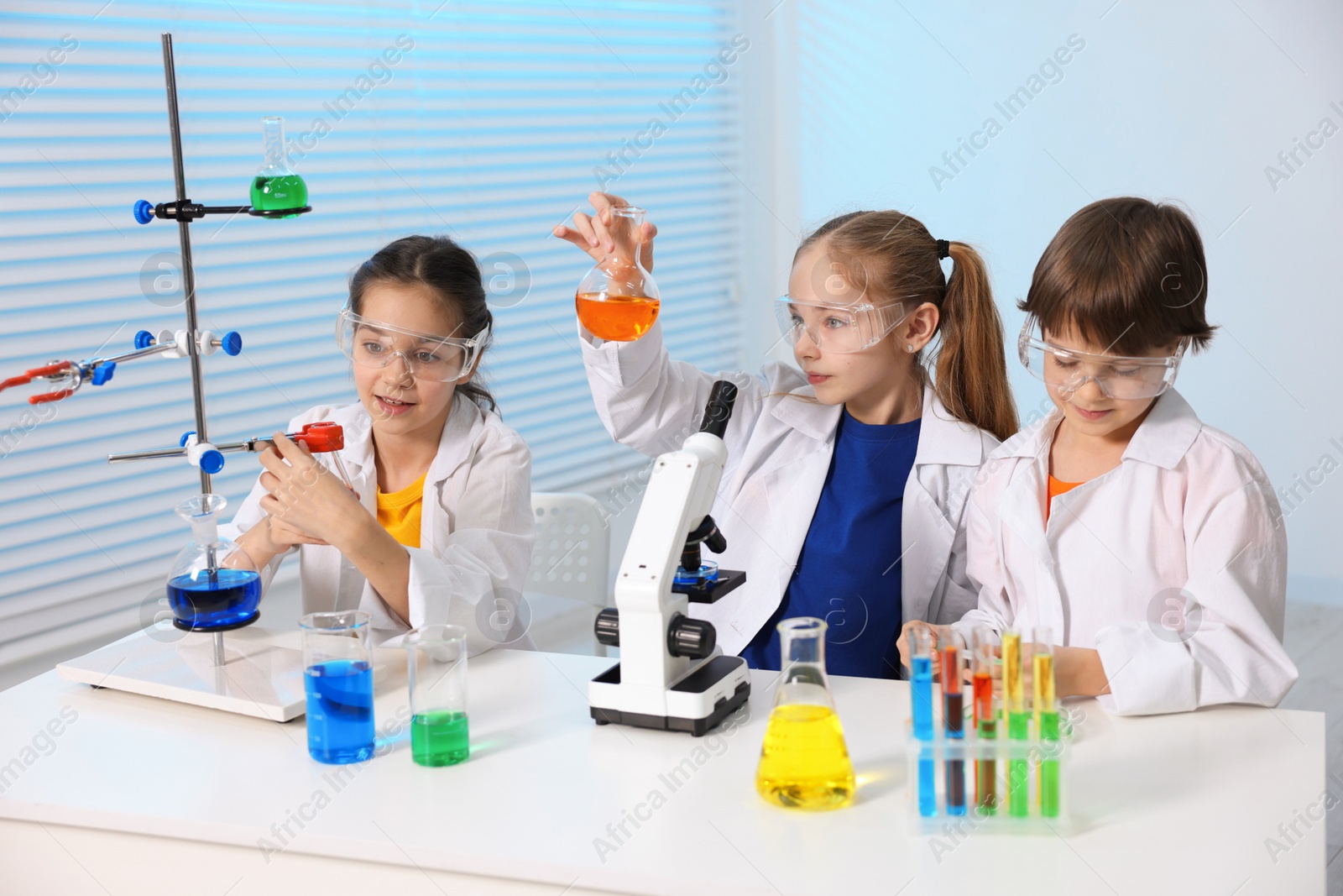 Photo of Children doing chemical experiment at desk indoors