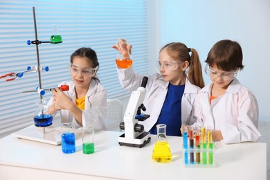 Photo of Children doing chemical experiment at desk indoors