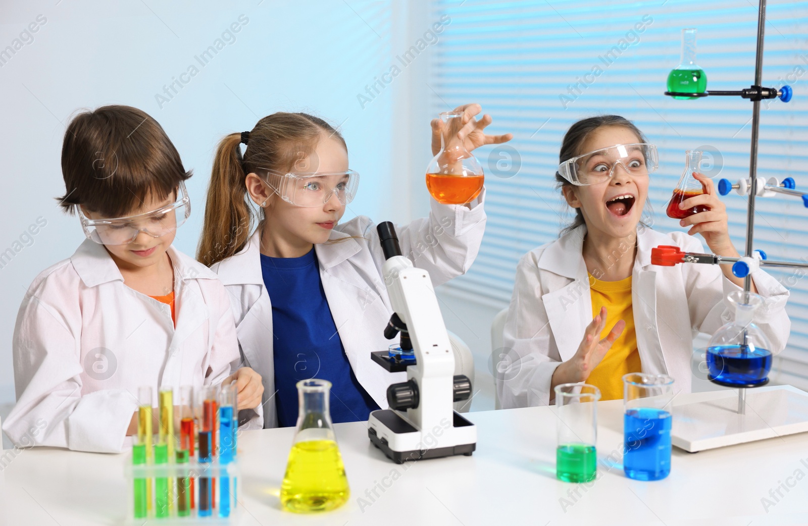 Photo of Children doing chemical experiment at desk indoors