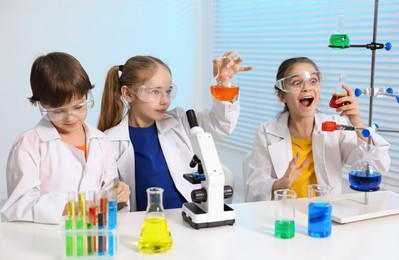 Photo of Children doing chemical experiment at desk indoors