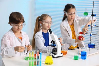 Children doing chemical experiment at desk indoors