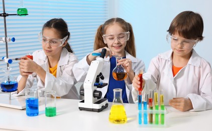 Children doing chemical experiment at desk indoors