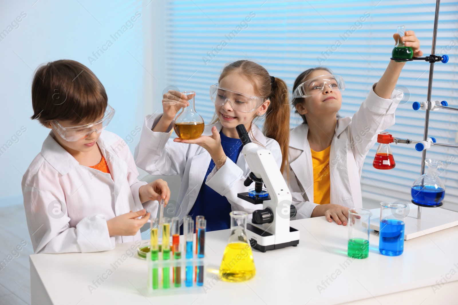 Photo of Children doing chemical experiment at desk indoors