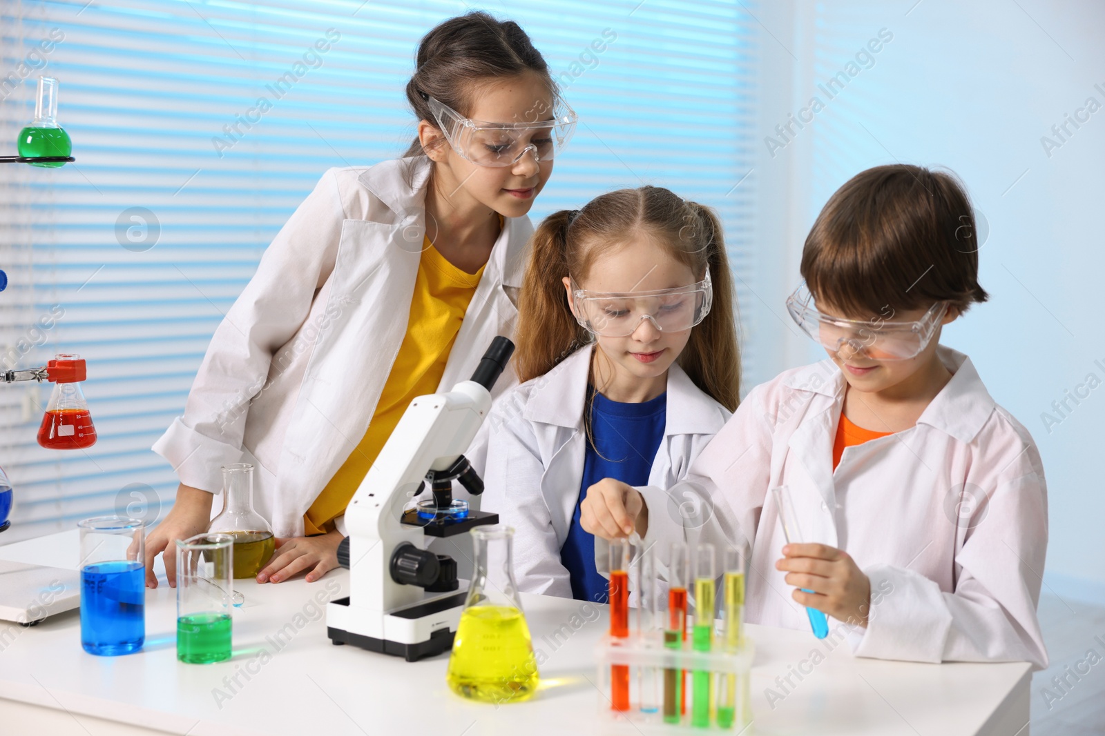 Photo of Children doing chemical experiment at desk indoors