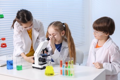 Photo of Children doing chemical experiment at desk indoors