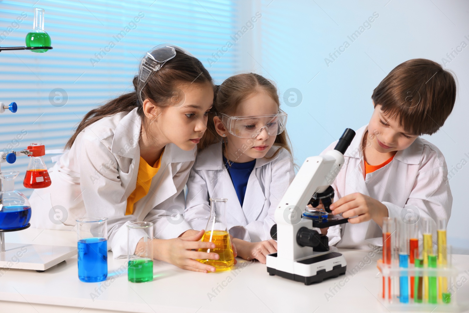 Photo of Children doing chemical experiment at desk indoors