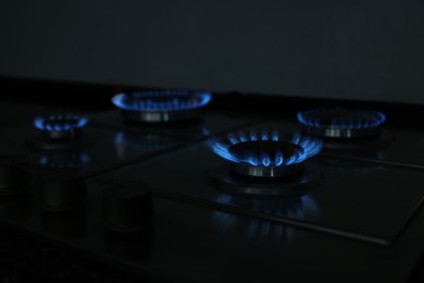 Photo of Gas burners with blue flame on stove, closeup