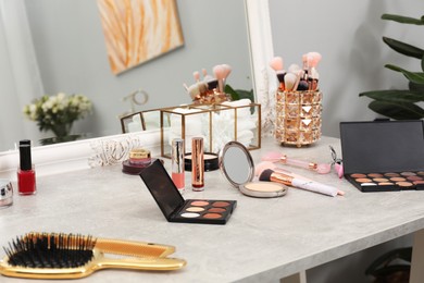 Photo of Makeup room. Different beauty products on dressing table and mirror indoors