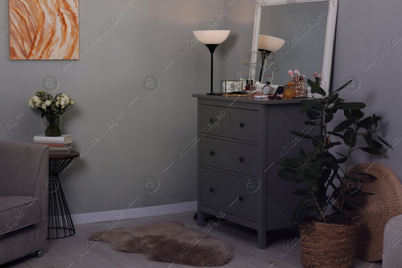 Photo of Makeup room. Mirror, dresser, different beauty products and houseplant indoors