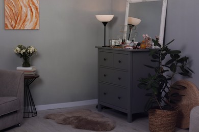 Makeup room. Mirror, dresser, different beauty products and houseplant indoors