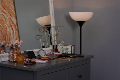 Photo of Makeup room. Mirror, dresser, different beauty products and jewelry indoors