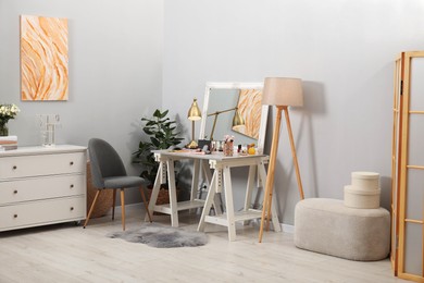 Photo of Makeup room. Mirror, dressing table, different beauty products and chair indoors