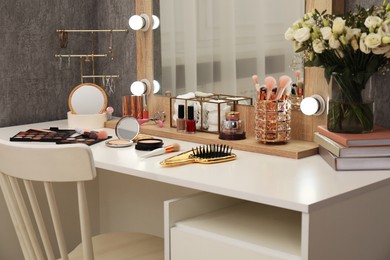 Photo of Makeup room. Mirror, dressing table, different beauty products and chair indoors