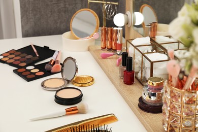 Photo of Makeup room. Different beauty products on white dressing table and mirror indoors, closeup