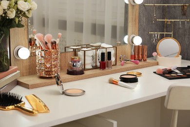 Photo of Makeup room. Different beauty products on white dressing table and mirror indoors