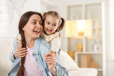 Photo of Portrait of happy mother and her cute daughter at home. Space for text