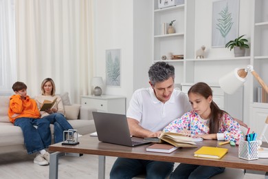 Photo of Parents and their children doing homework at home