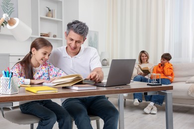 Photo of Parents and their children doing homework at home