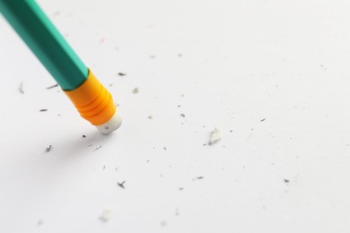 Photo of Using pencil with eraser on white sheet of paper, closeup