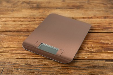 Photo of Modern electronic kitchen scale on wooden table, closeup