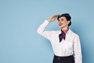 Smiling flight attendant on light blue background. Space for text