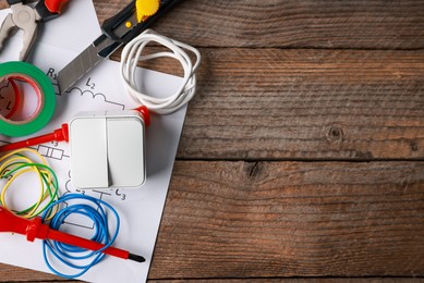 Photo of Different electrical tools and circuit diagram on wooden table, flat lay. Space for text