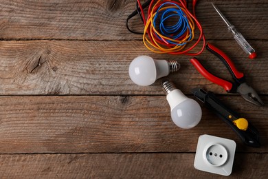 Photo of Different electrical tools on wooden table, flat lay. Space for text