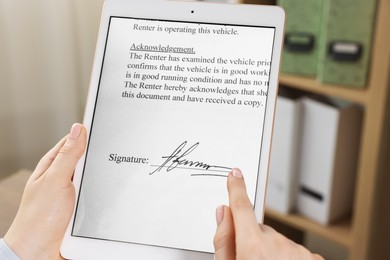 Photo of Electronic signature. Woman using tablet indoors, closeup