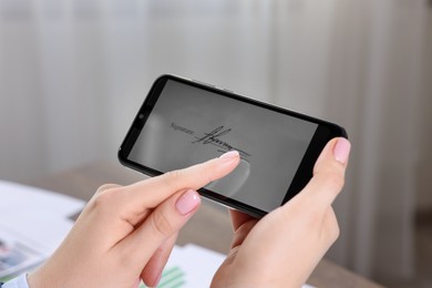 Photo of Electronic signature. Woman using smartphone indoors, closeup