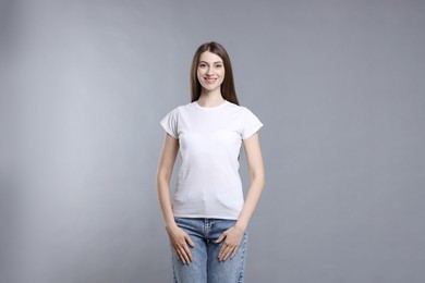 Photo of Woman wearing blank white t-shirt on light grey background. Mockup for design