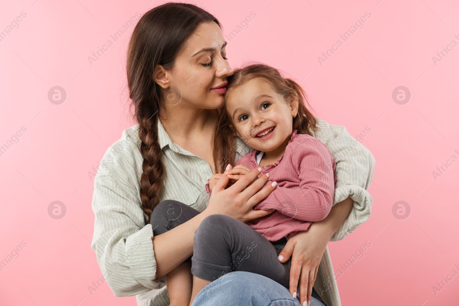 Photo of Portrait of mother with her cute daughter on pink background