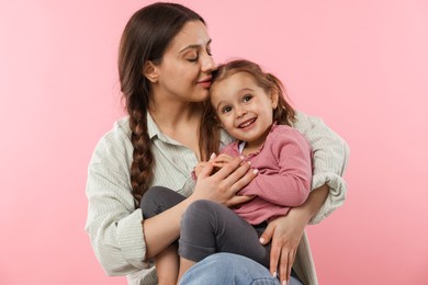 Photo of Portrait of mother with her cute daughter on pink background