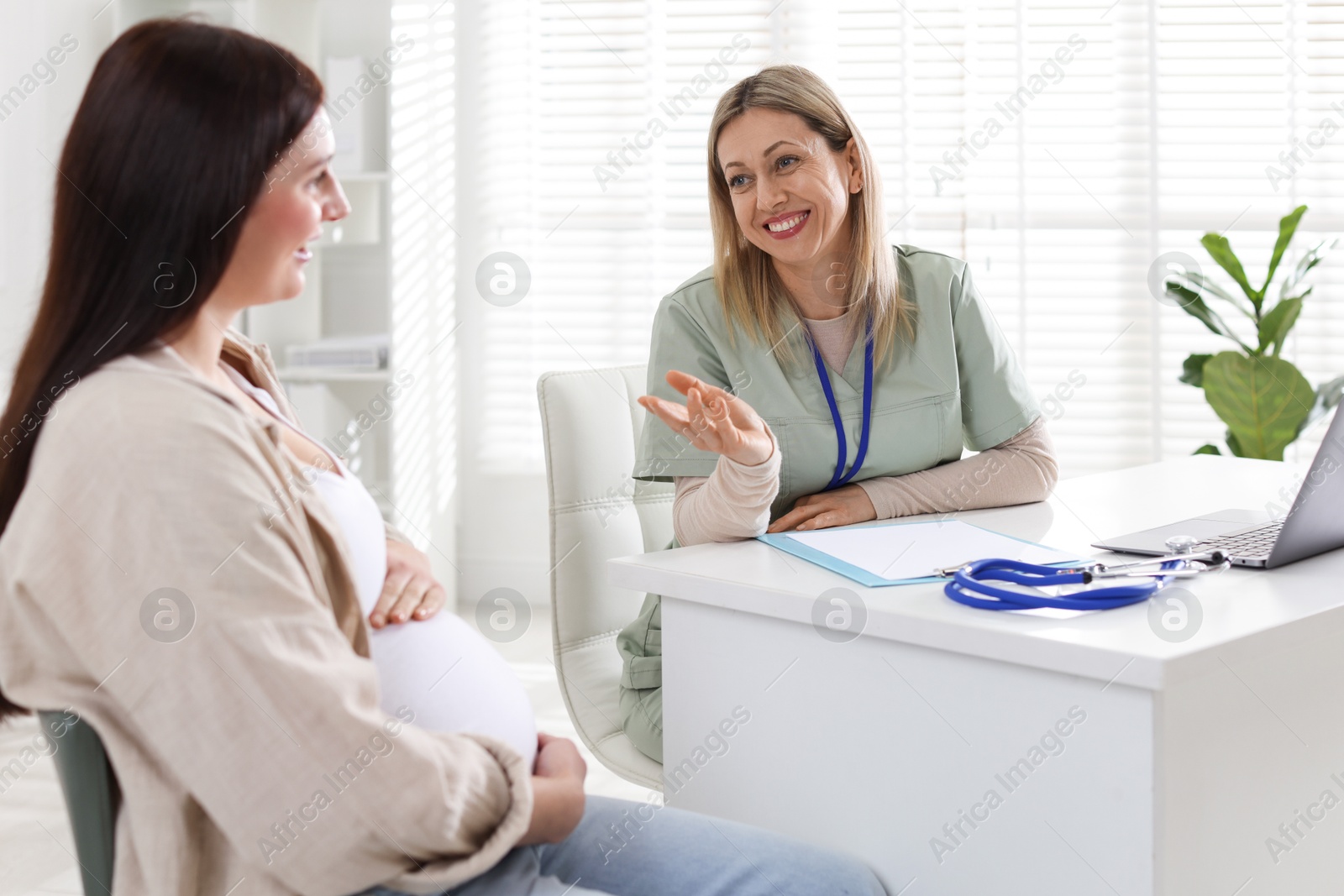 Photo of Pregnant woman having appointment with doctor in clinic