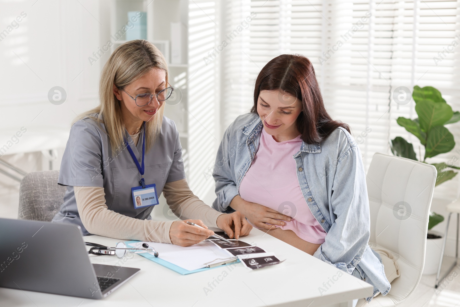 Photo of Pregnant woman having appointment with doctor in clinic