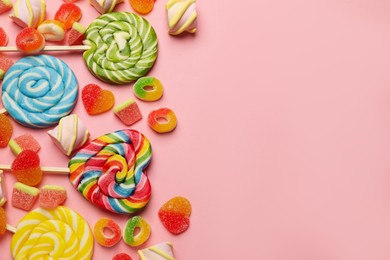 Many different tasty candies and marshmallows on pink background, flat lay. Space for text