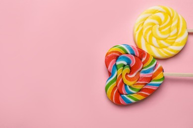 Tasty lollipops on pink background, flat lay. Space for text