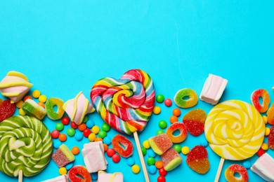 Photo of Many different tasty candies and marshmallows on light blue background, flat lay. Space for text