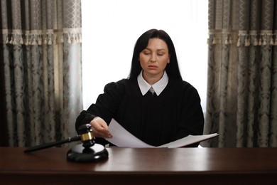 Judge with documents at wooden table in office