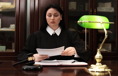 Judge working with documents at wooden table in office