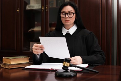 Judge with document at table in office