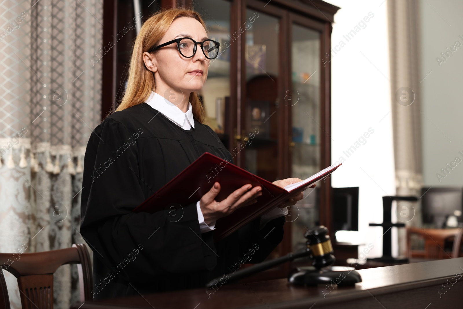 Photo of Judge with folder of documents in courtroom