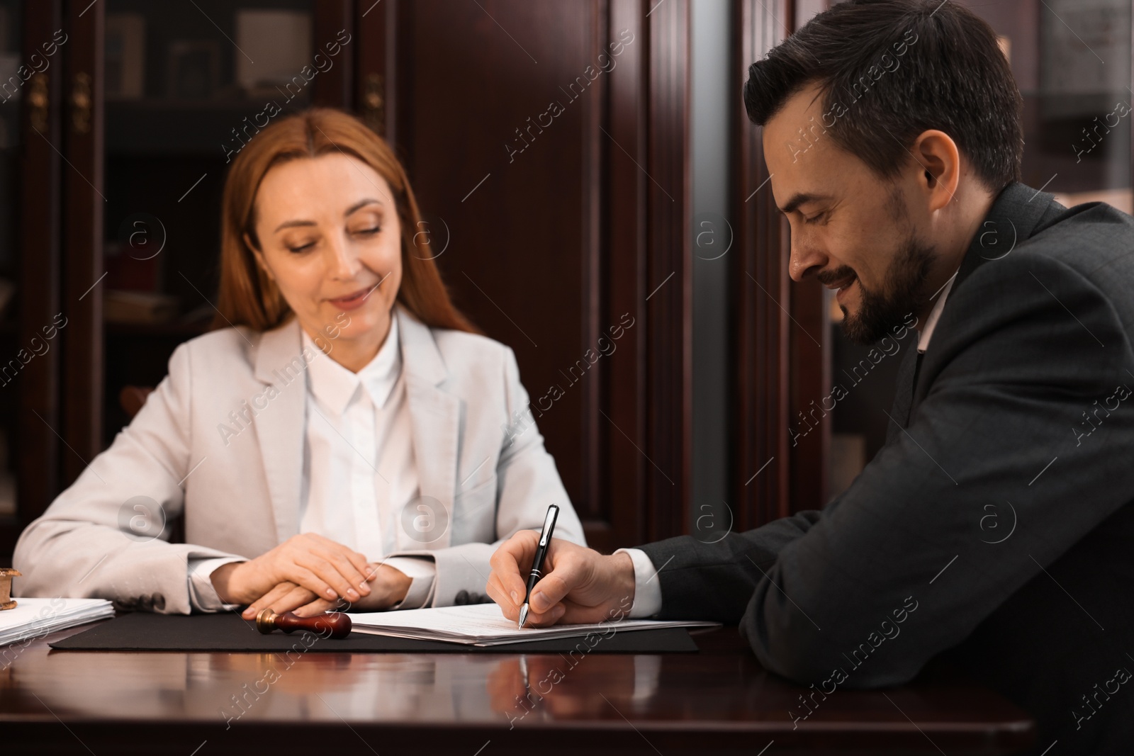 Photo of Notary working with client at table in office