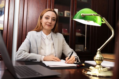 Photo of Notary doing paperwork at table in office