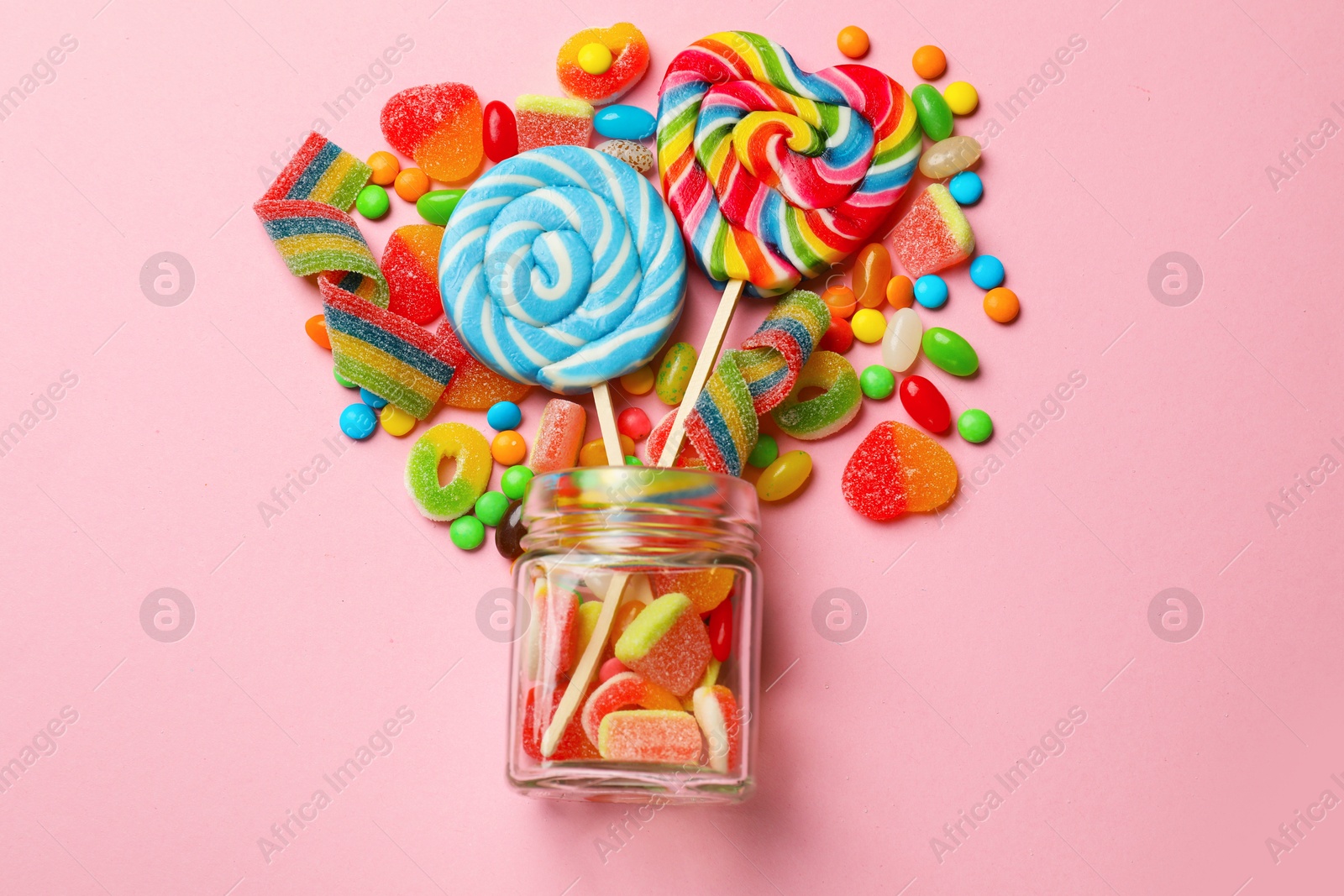 Photo of Many different tasty candies on pink background, flat lay