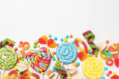 Photo of Many different tasty candies and marshmallows on white background, flat lay. Space for text