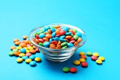 Colorful sugar coated dragee candies on blue background, closeup