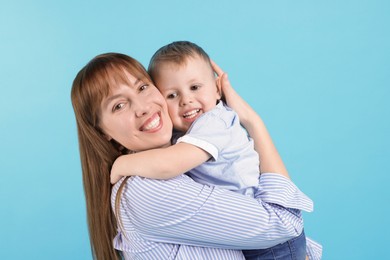 Photo of Mother and her cute son on light blue background